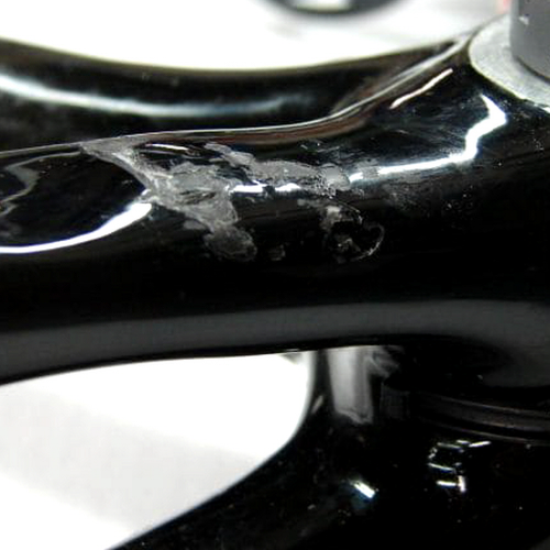 카본 자전거 프레임의 도장 까짐과 크랙을 비교하는 근접 장면