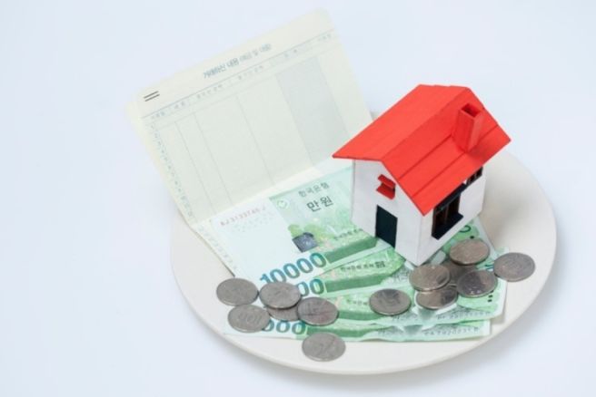 저금통&amp;#44; 통장&amp;#44; 지폐와 동전 위에 놓인 주택 모형