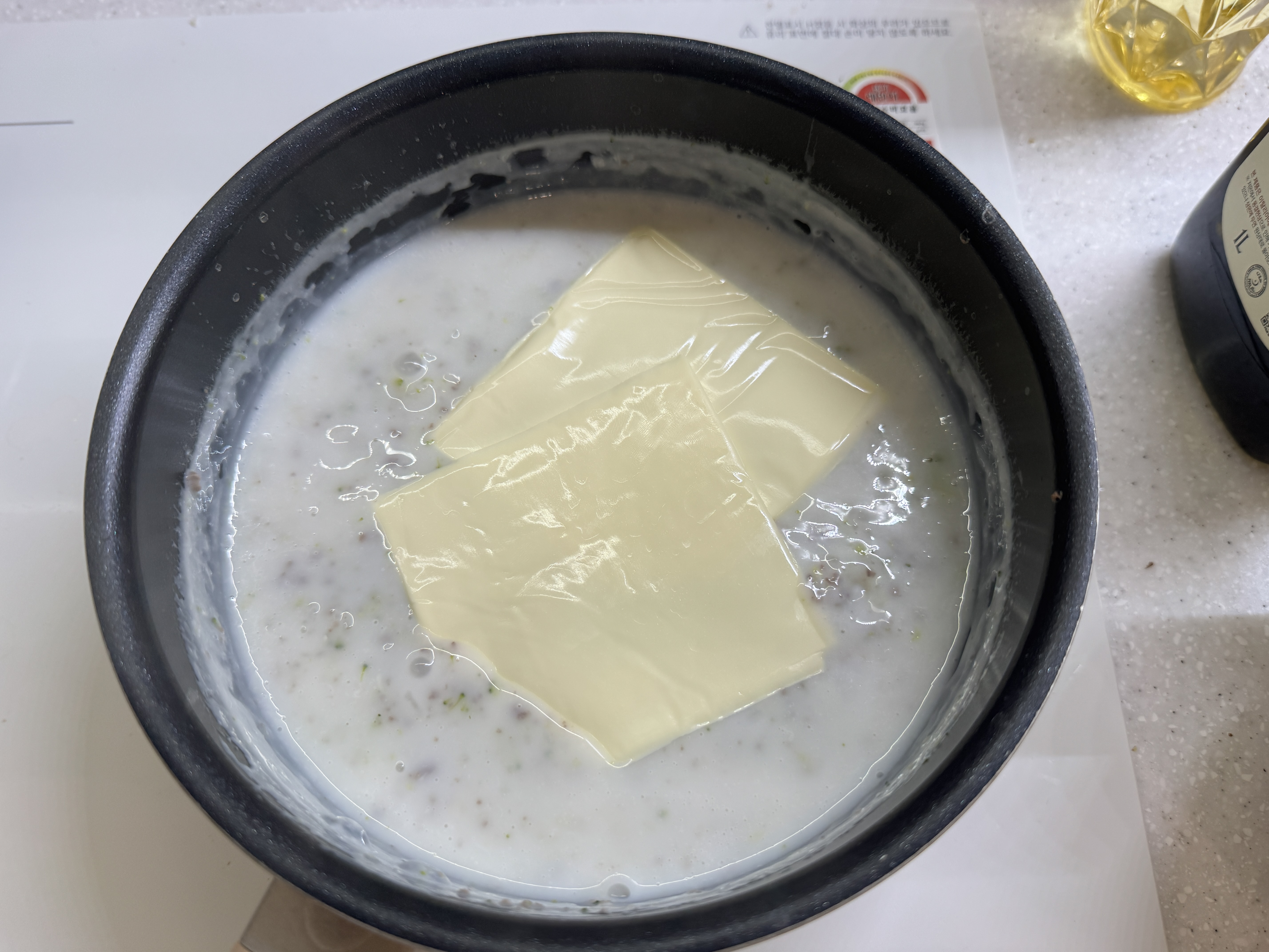 냄비에 쌀, 브로콜리, 버섯, 소고기, 분유를 넣고 끓기 시작할 때 치즈를 넣은 사진