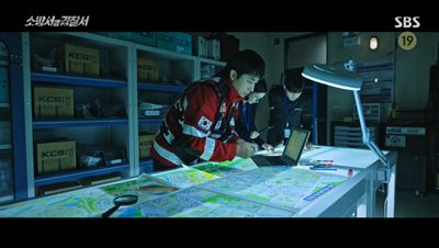 현서 팔의 문신을 토대로 지도를 보면서 납치장소를 찾고 있는 소방과 경찰