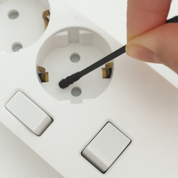 면봉으로 멀티탭을 청소하는 모습