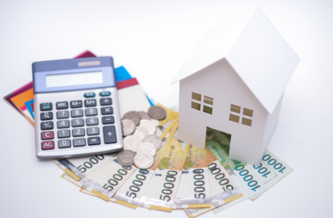 집 모형과 지폐들이 널려있고 계산기도 그 위에 있다.