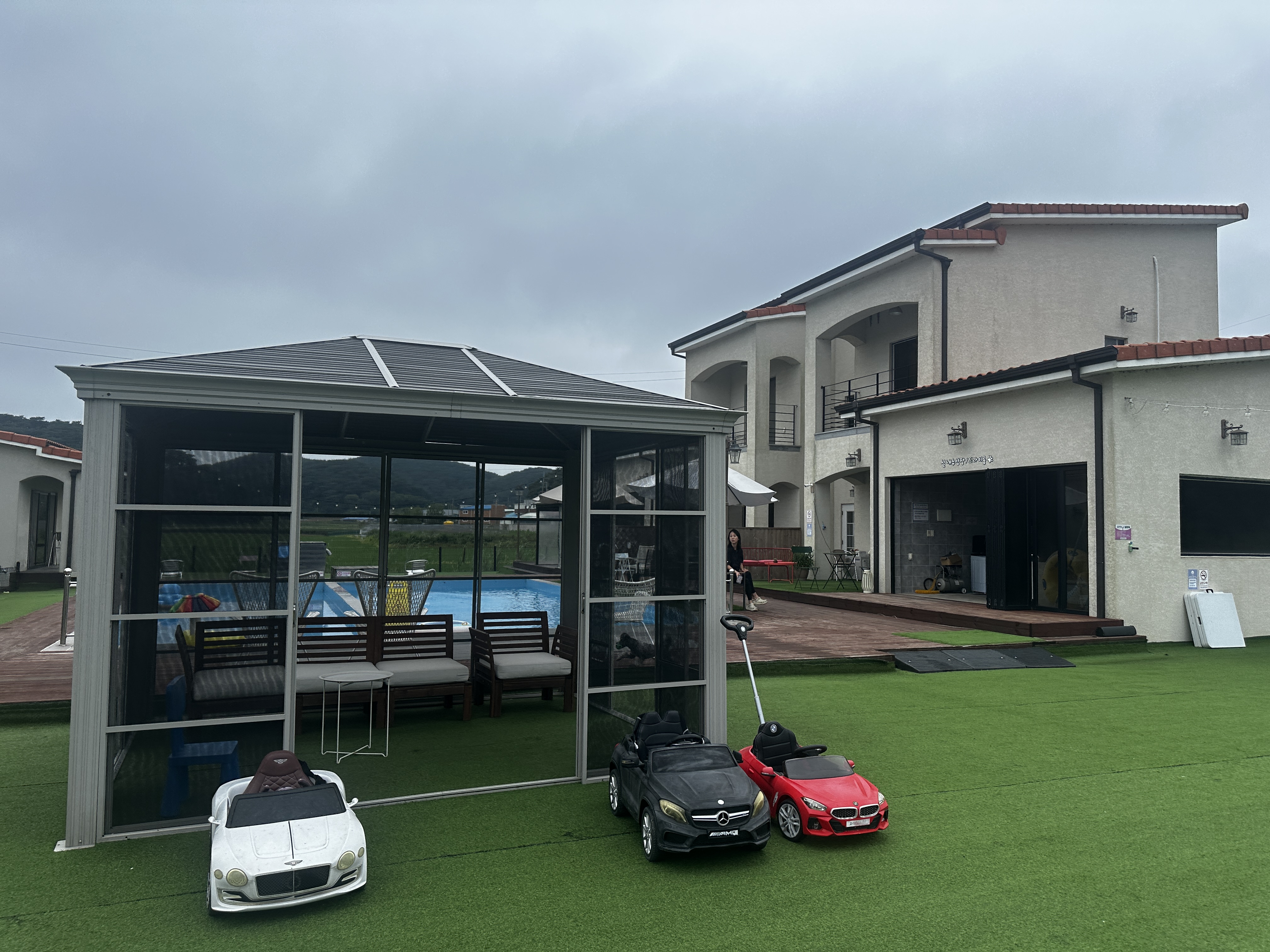 골드독펜션 측면사진 건물앞에 원두막 슈퍼카 3대있는 모습