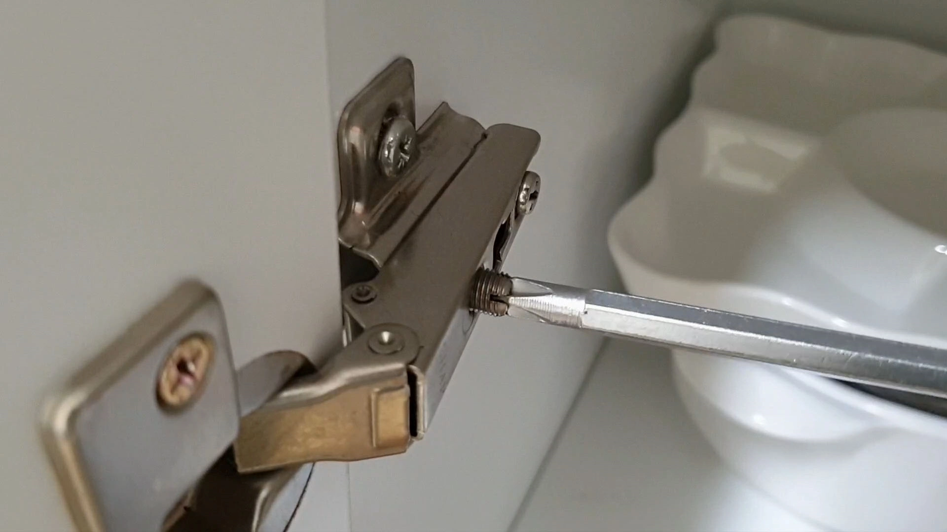 경첩 볼트 조정하는 모습