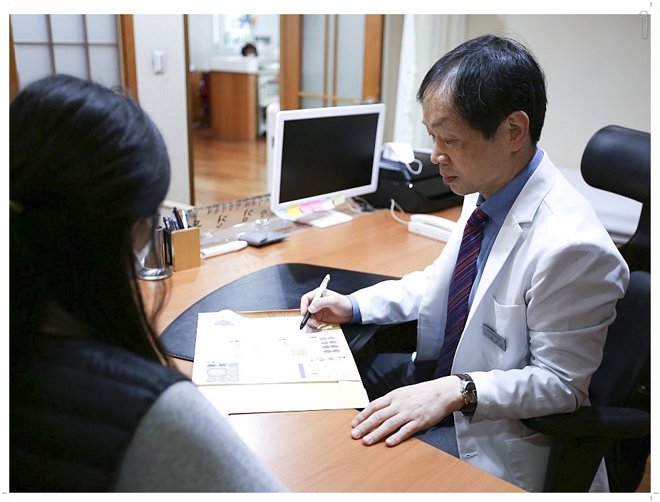 차트를 보며 진료를 보고 있는 남성 한의사의 모습