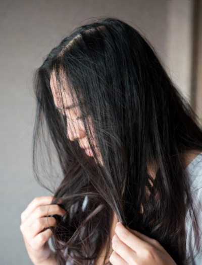 산후 탈모로 머리카락 빠짐을 걱정하는 여성 모습