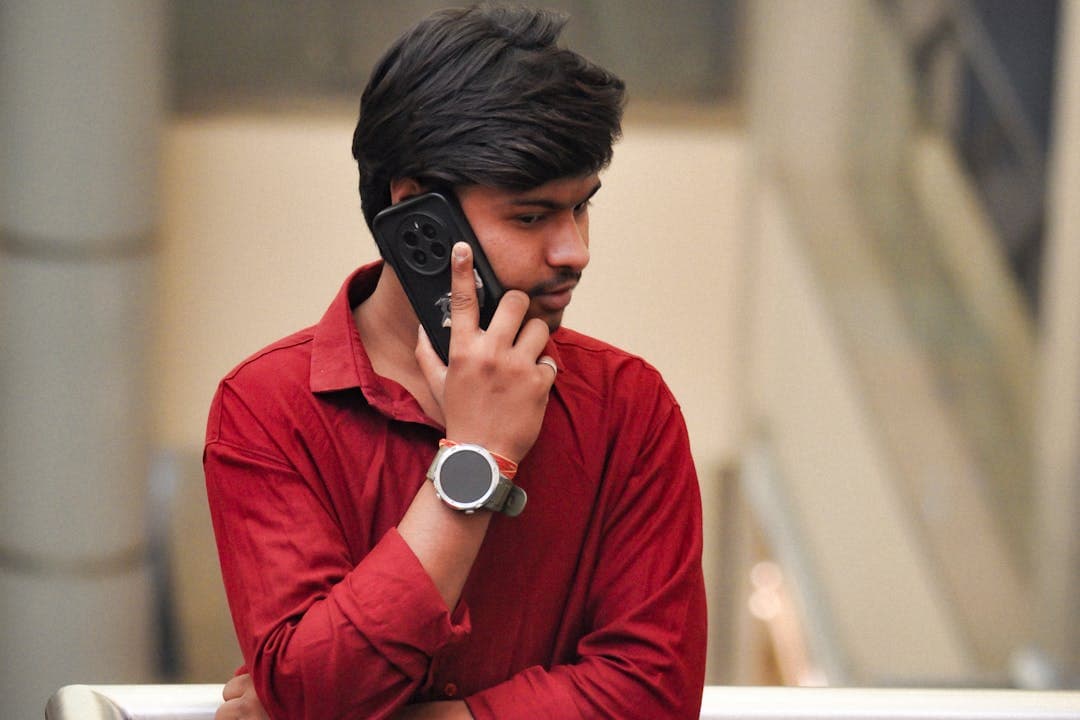 통화 중인 젊은 남성, 낯선 번호로 온 금융사기 전화에 경계하는 모습