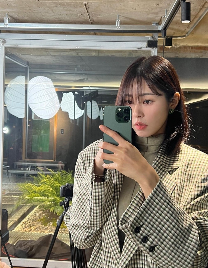 체크자켓을입고-핸드폰을들고있는-긴머리여성의모습