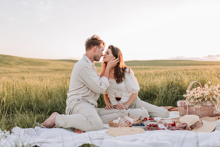 A couple enjoying a romantic picnic at sunset, surrounded by nature.
