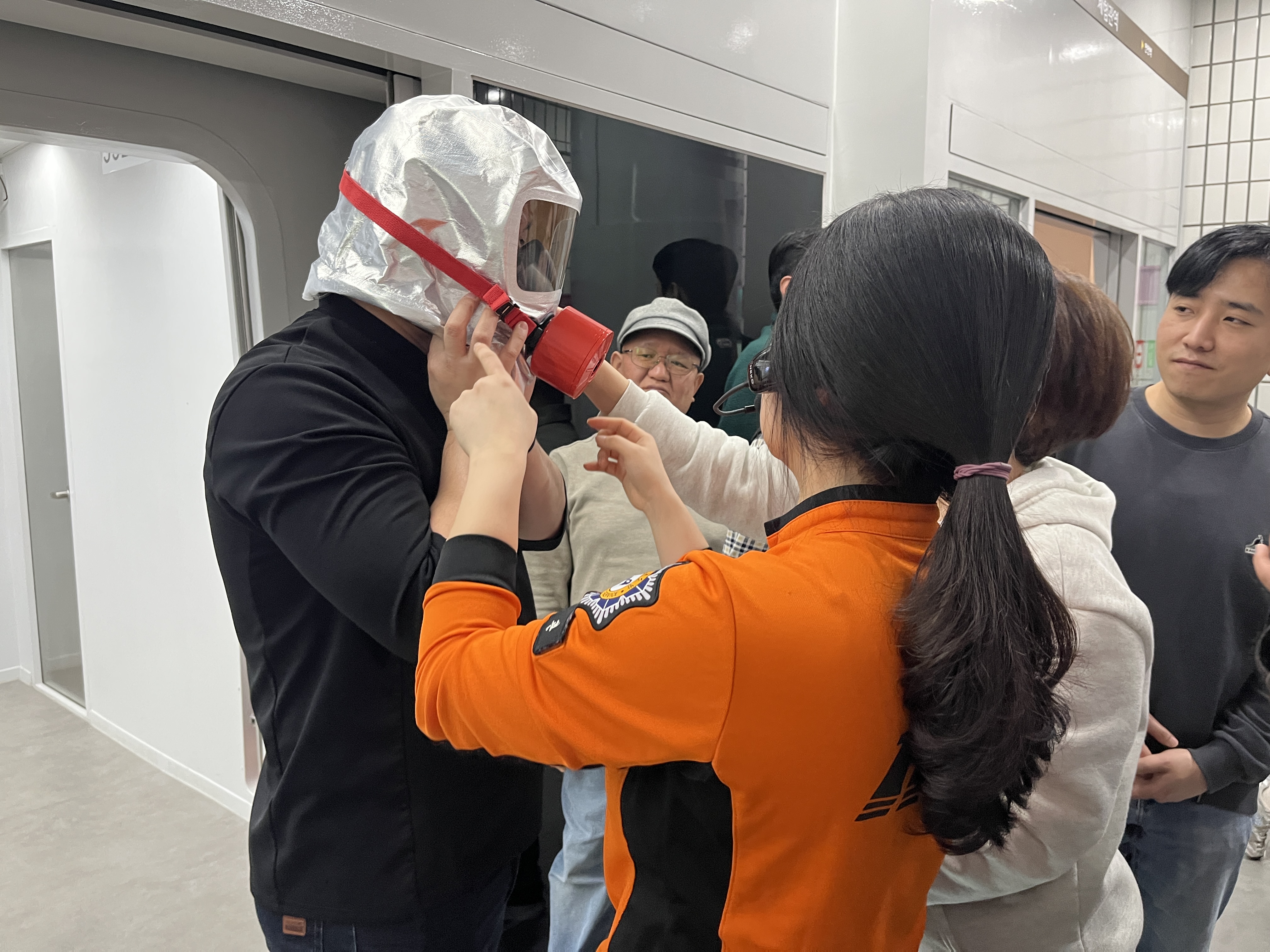 지하철 역에 비치된 화재방독면을 써보고 있다.