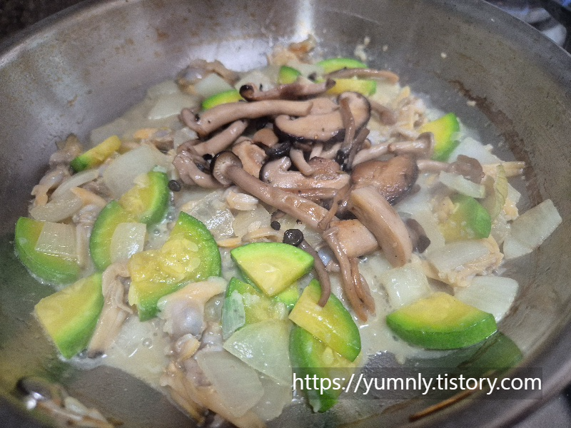 Mixing pre-sautéed assorted mushrooms into the pan to add depth and earthy flavor.