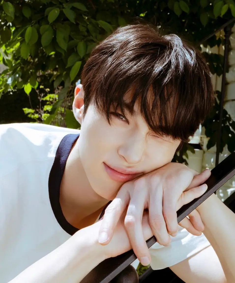 초록 나무 앞 흰티를 입고 윙크하는 변우석