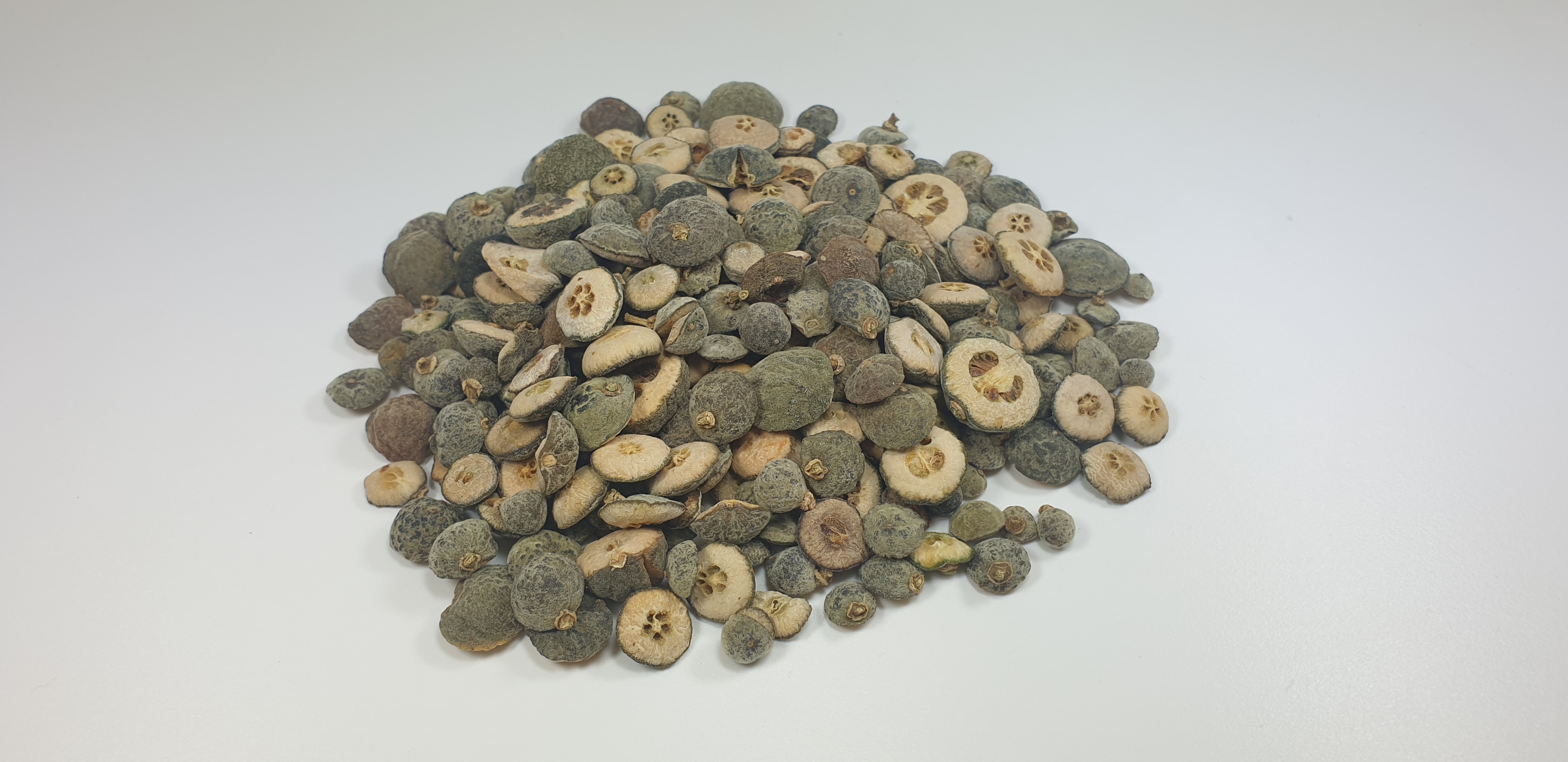 야생에서 채취를 한 탱자나무 열매인 지실을 깨끗이 세척을 해서 말린 후에 잘라서&#44; 하얀 바닥 위에 수북하게 쌓아 놓은 사진