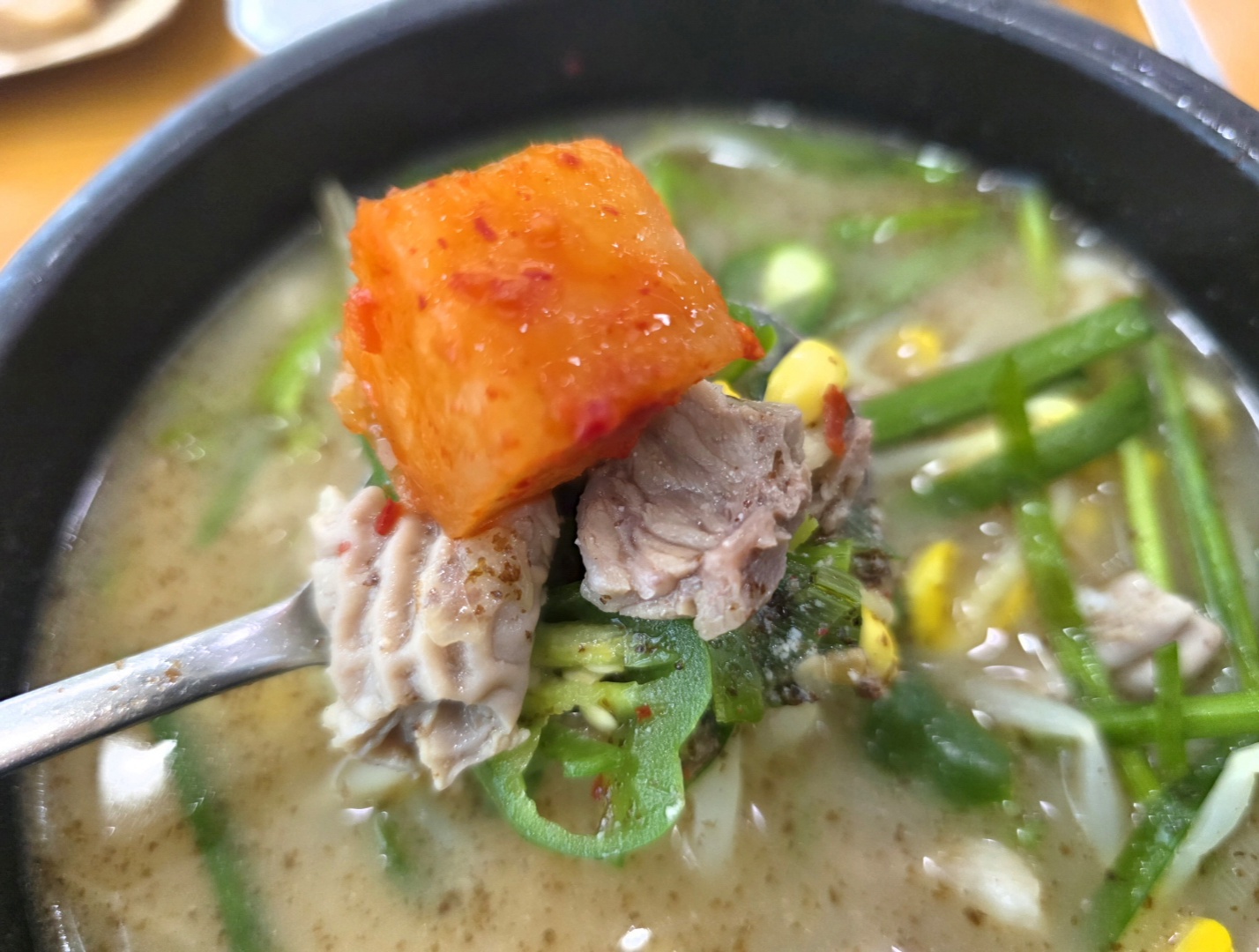 순댓국 돼지고기와 깍두기를 함께 올린 한 숟가락