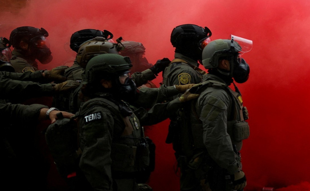 포틀랜드의 이민세관단속국(ICE) 본부 앞에서 벌어진 시위에 맞서 연방요원들이 연막을 피우고 있다.