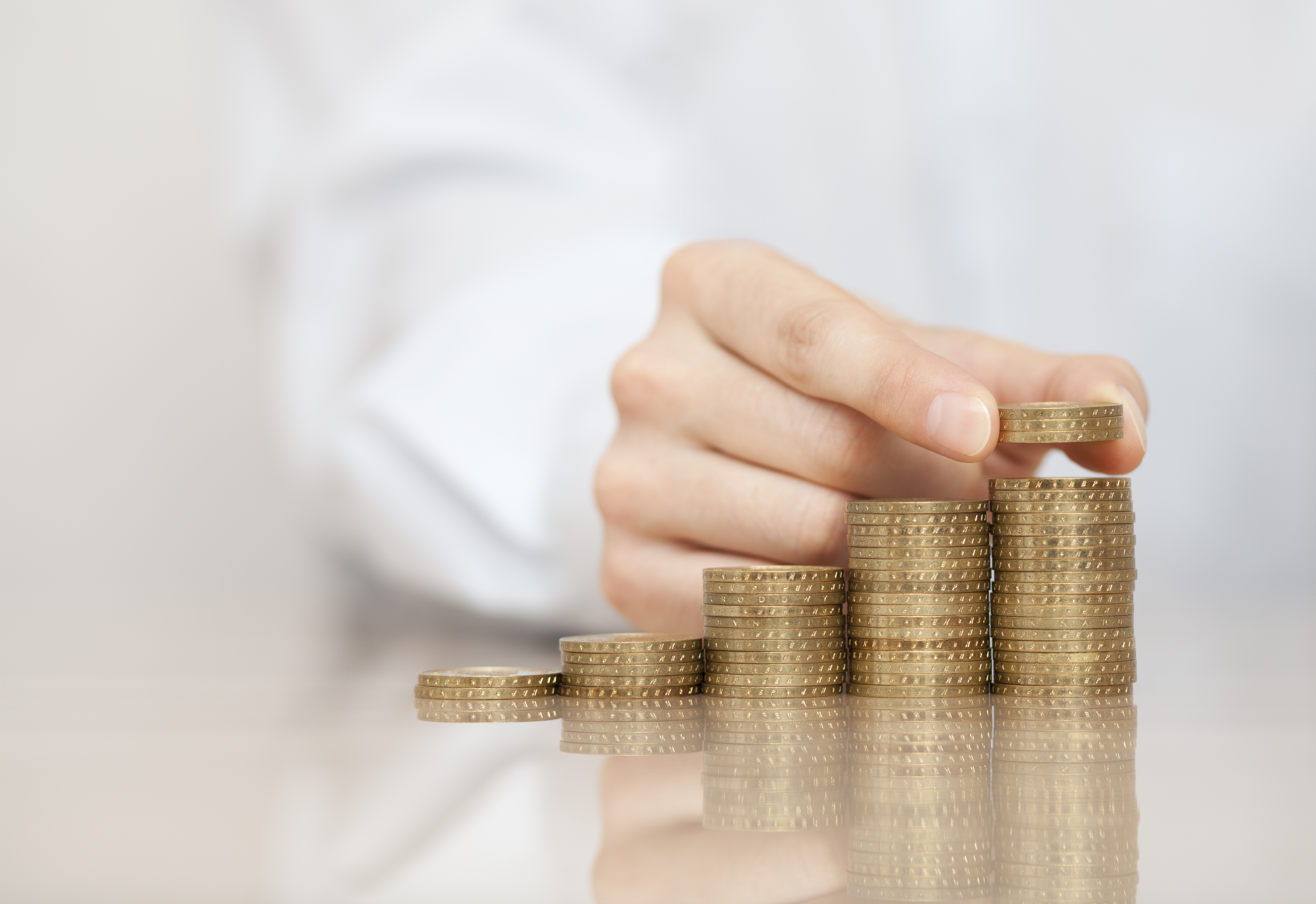 동전을 차곡차곡 쌓으며 월 배당 ETF에 투자하는 손의 모습