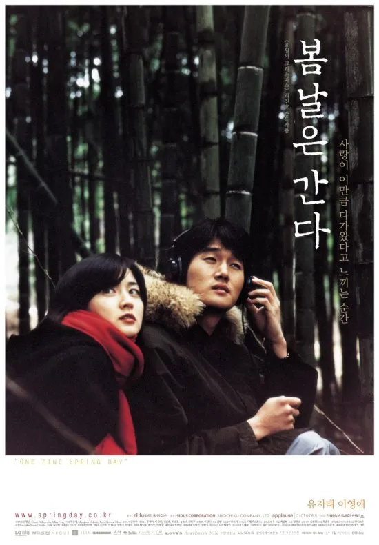 영화 '봄날은 간다' 포스터. 대나무숲 속에서 헤드폰으로 소리를 듣는 남성과 붉은 목도리를 한 여성이 함께 앉아 있는 장면.