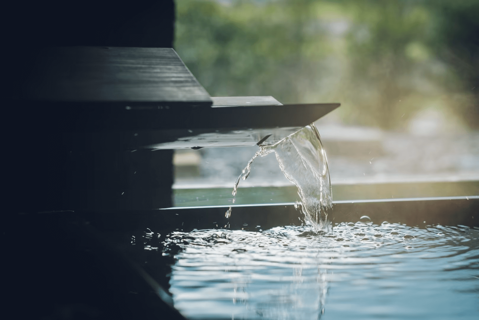 온천 물이 흐르는 현대적인 구조의 온천 시설 클로즈업. 깨끗하고 고요한 분위기.