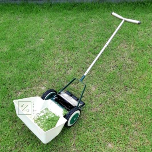 잔디 깎기가 잔디위에 놓여 있습니다.