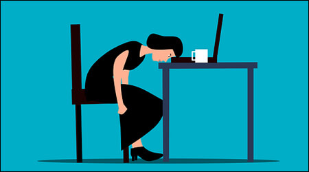 피곤해서 책상에 머리를 기대고 있는 여성