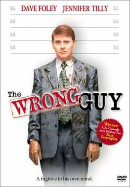 영화 The Wrong Guy 포스터에서 정장을 입은 남성이 신장 측정 배경 앞에 서 있는 모습