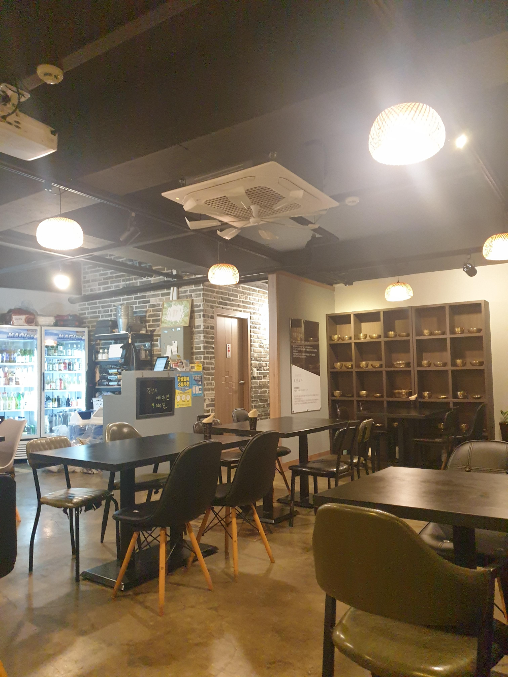 인더스트리얼 감성의 내부, 노출 콘크리트와 따뜻한 조명이 인상적이다.