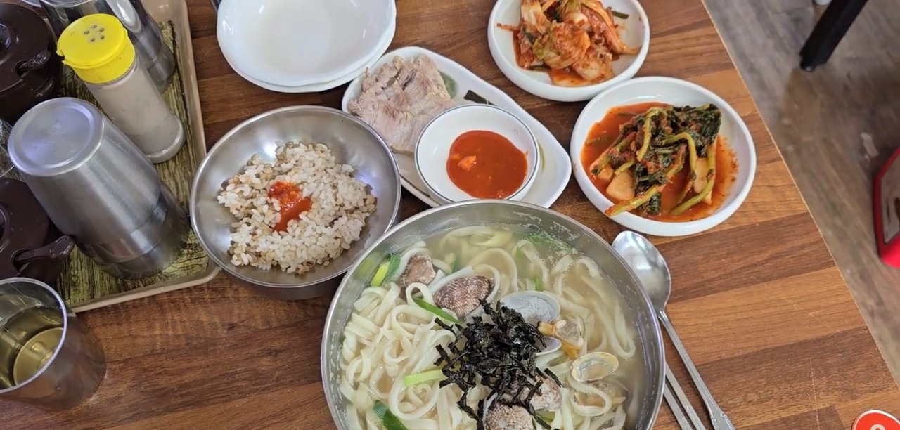 바지락칼국수와 보리밥, 수육, 김치가 차려진 상차림