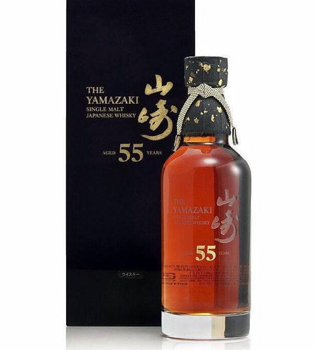 병안에 갈색 액체가 들어가 있고 영어로 '더 야마자키 싱글몰트 재패니즈 위스키 55년' 이라고 적혀 있는 박스가 위스키 뒤에 있다.