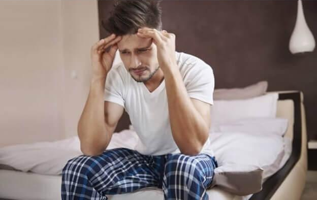 숙취로-침대에-앉아있는-남자