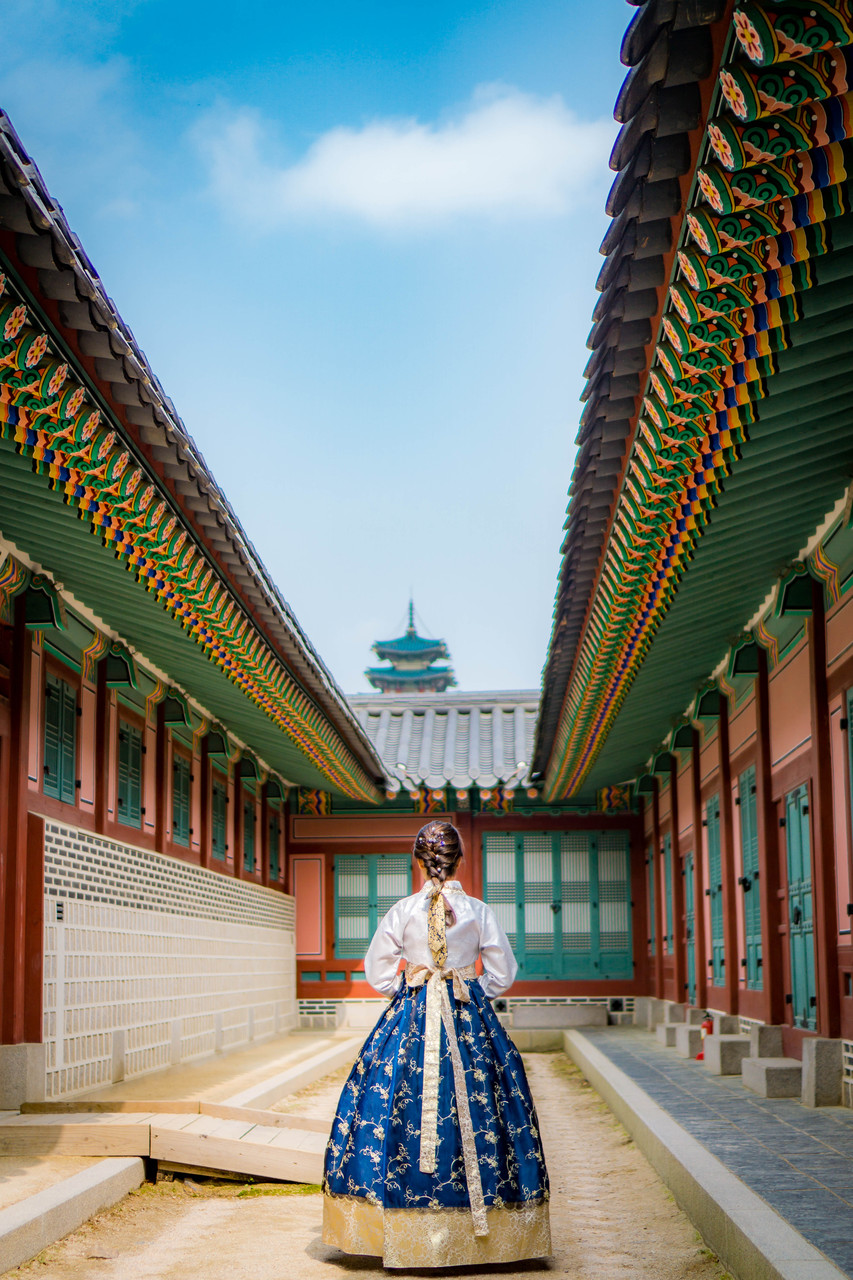 A girl standing between two buildings at Gyeongbokgung, wearing Hanbok