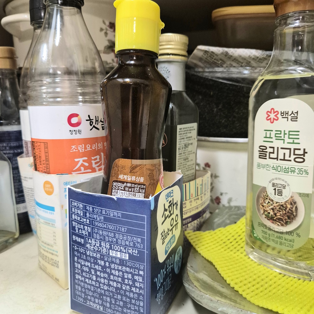 우유팩을 잘라 참기름병과 양념통 받침으로 활용하는 모습