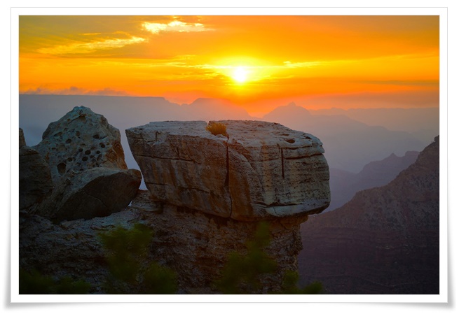 그랜드캐니언의 거대한 바위절벽위로 붉은노을이 지며 하늘이 오렌지색으로 물들어있는 장엄한 일몰풍경