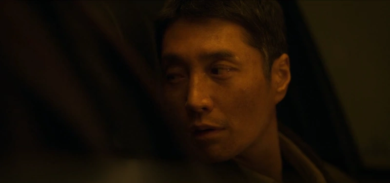 승용차 운전석에 갈색옷을 입고 짧은 머리를 하고 있는 드라마 무빙의 배재학 캐릭터