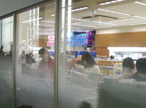 편의점 안에서 잡지를 보고있는 성인들