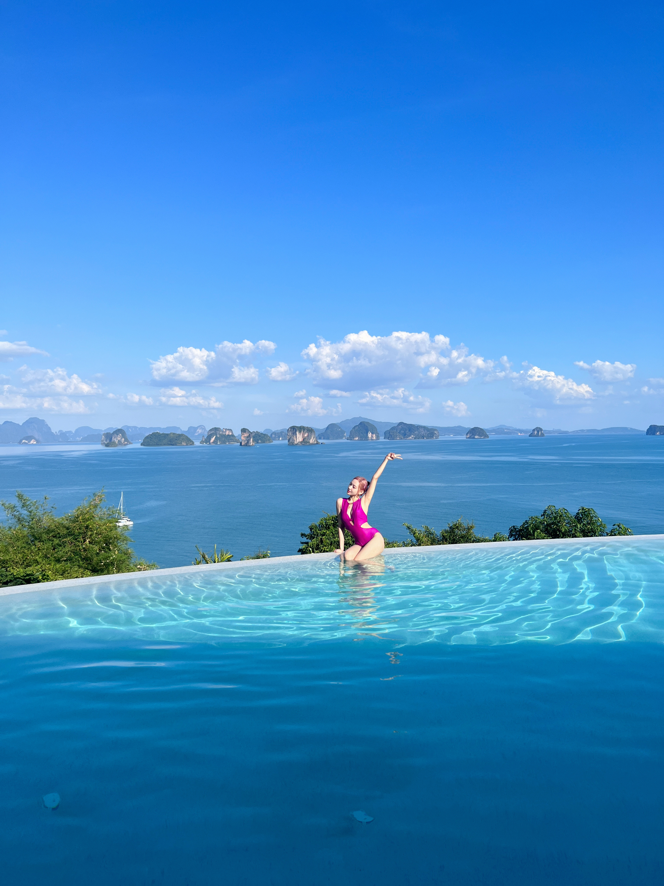 파란 하늘 아래에서 모노키니 차림으로 피스