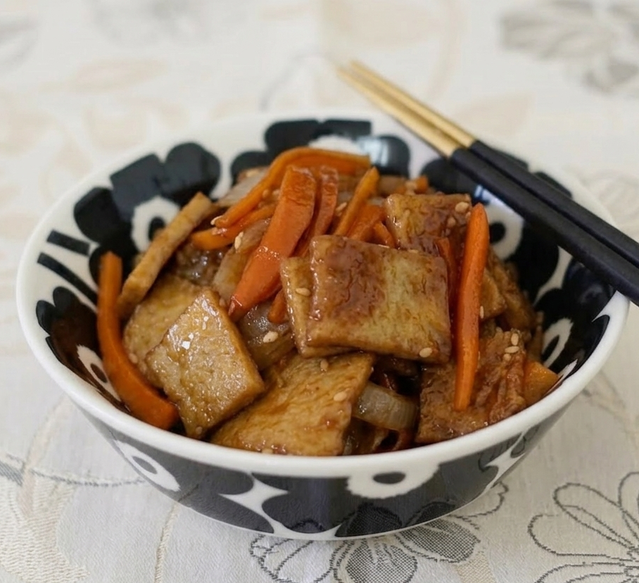 화사한 꽃무늬 매트 위, 세련된 블랙 패턴 접시에 정갈하게 담긴 간장 어묵볶음.