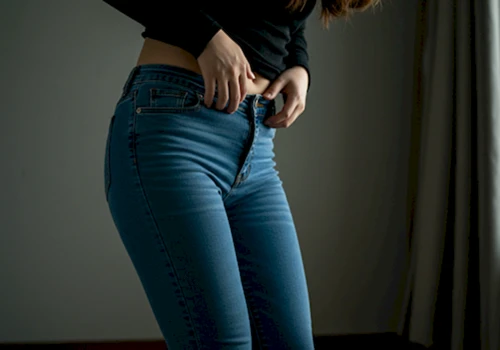 꽉 끼는 옷차림으로 Y존 불편함을 느끼며 괴로워하는 한국인 여성의 하반신. 답답한 옷의 질감이 사실적으로 표현됩니다.