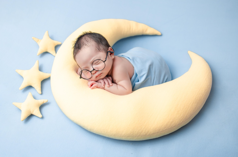 출산 후 신생아 촬영, 달 모양 쿠션 위에서 잠든 안경 쓴 아기 감성 사진