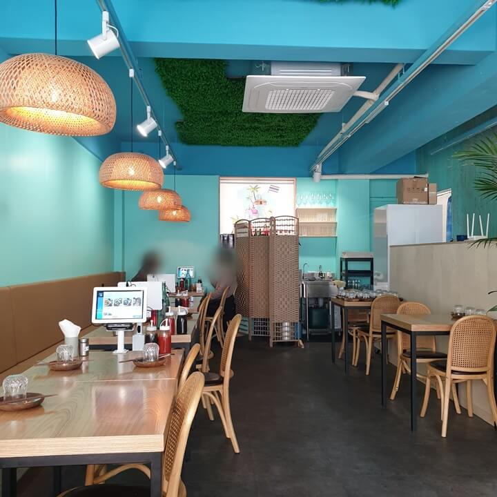 양재-피넘타이의-2인석과-4인석-테이블이-있고-테이블의-키오스크가-보인다