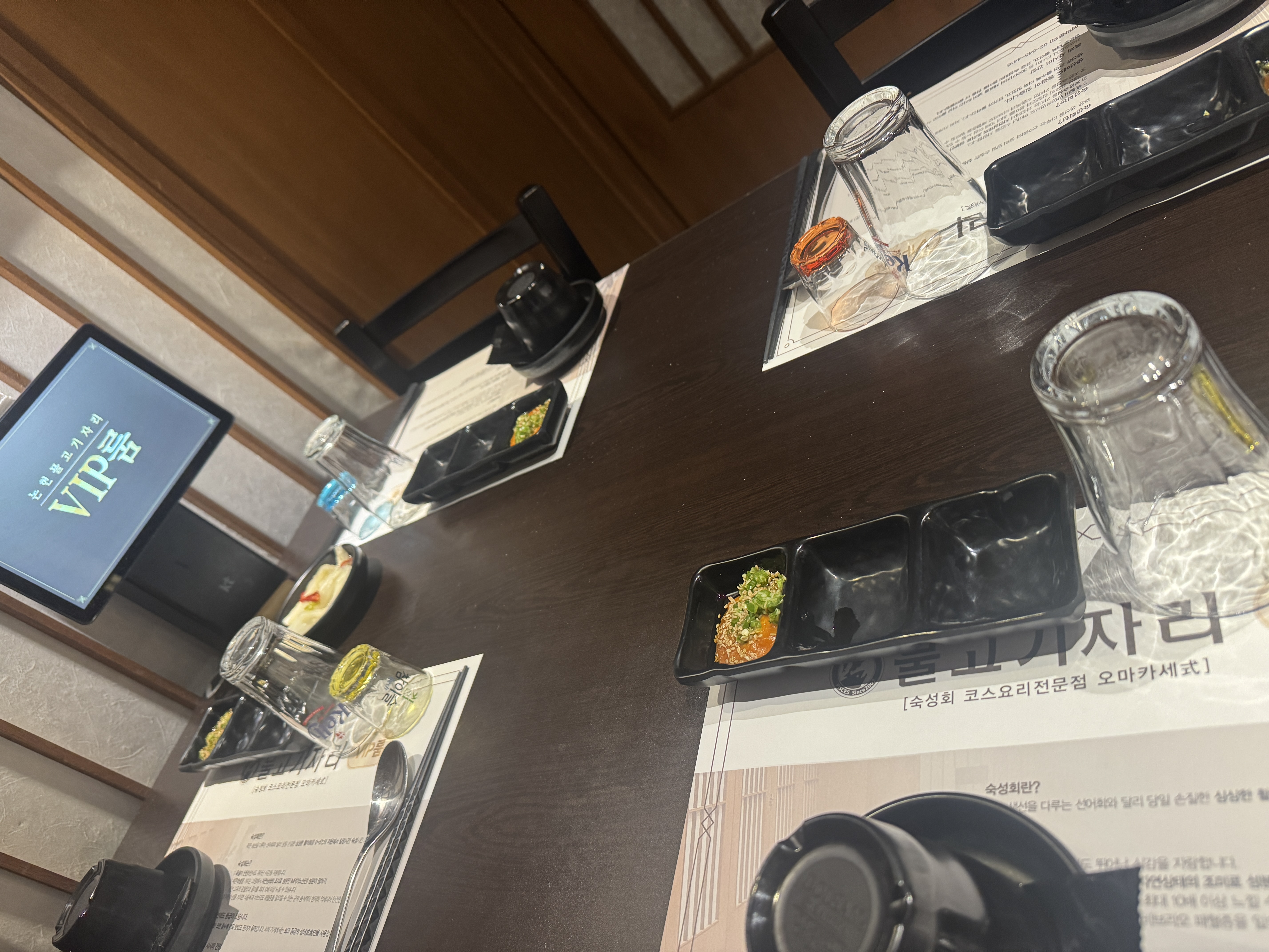 물고기자리 논현점 VIP룸 내부 테이블 세팅&amp;#44; 개별 앞접시&amp;#44; 소스용 그릇&amp;#44; 물컵&amp;#44; 메뉴판이 가지런히 준비됨