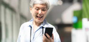 스마트폰 앱 화면을 보며 미소 짓고 있는 어르신이나 직장인의 모습