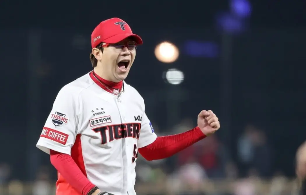 흰 기아타이거즈 유니폼 붉은 야구모자를 쓰고 왼손을 불끈 쥔채 환호하고 있는 양현종