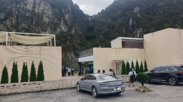 주차장과 건물 그 뒤로 절벽이 보인다.