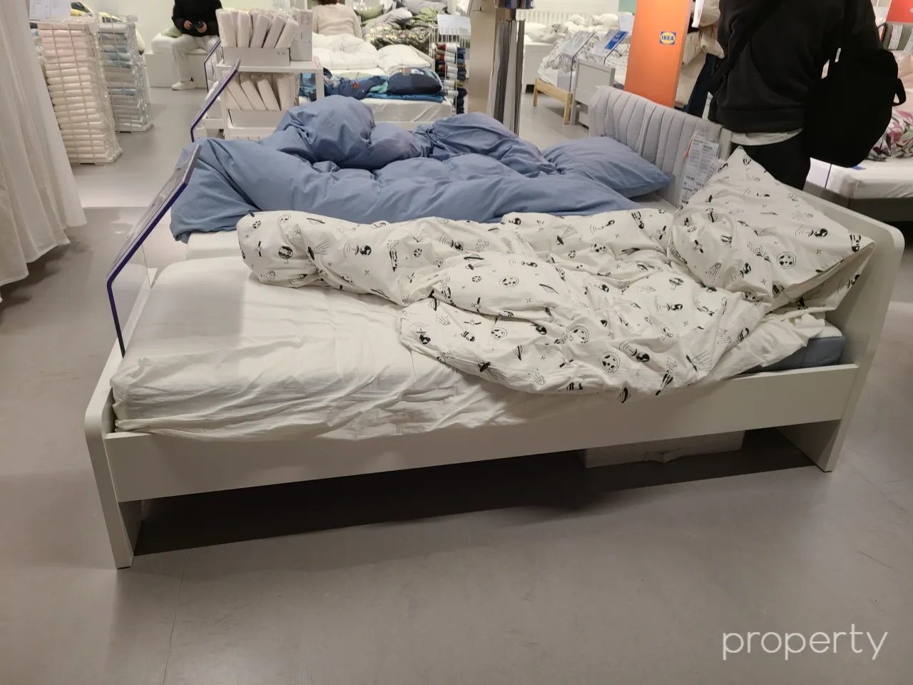이케아매장-진열된화이트침대-다리형침대-흰색바탕검은색무늬이불