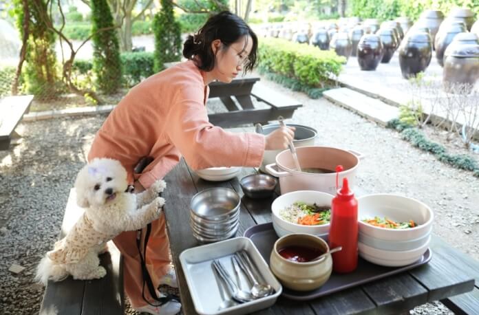 식사준비하는 사람과 옆에 있는 강아지