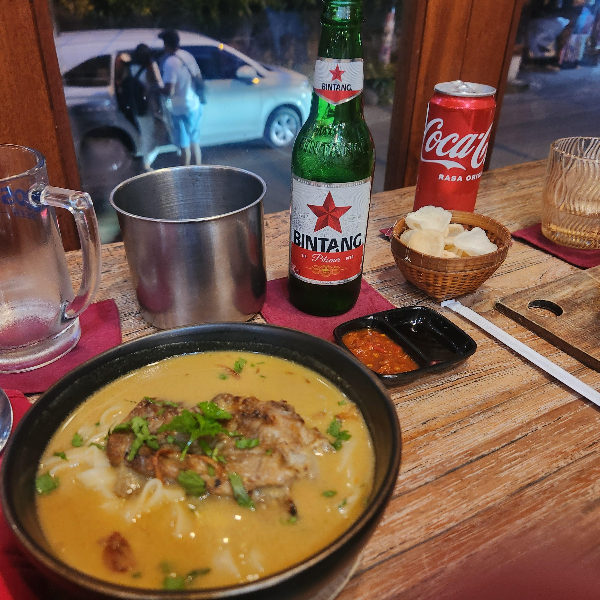 맥주와 코카콜라 그리고 노란색 면요리가 보인다. 삼발 소스가 중간에 놓여있다.