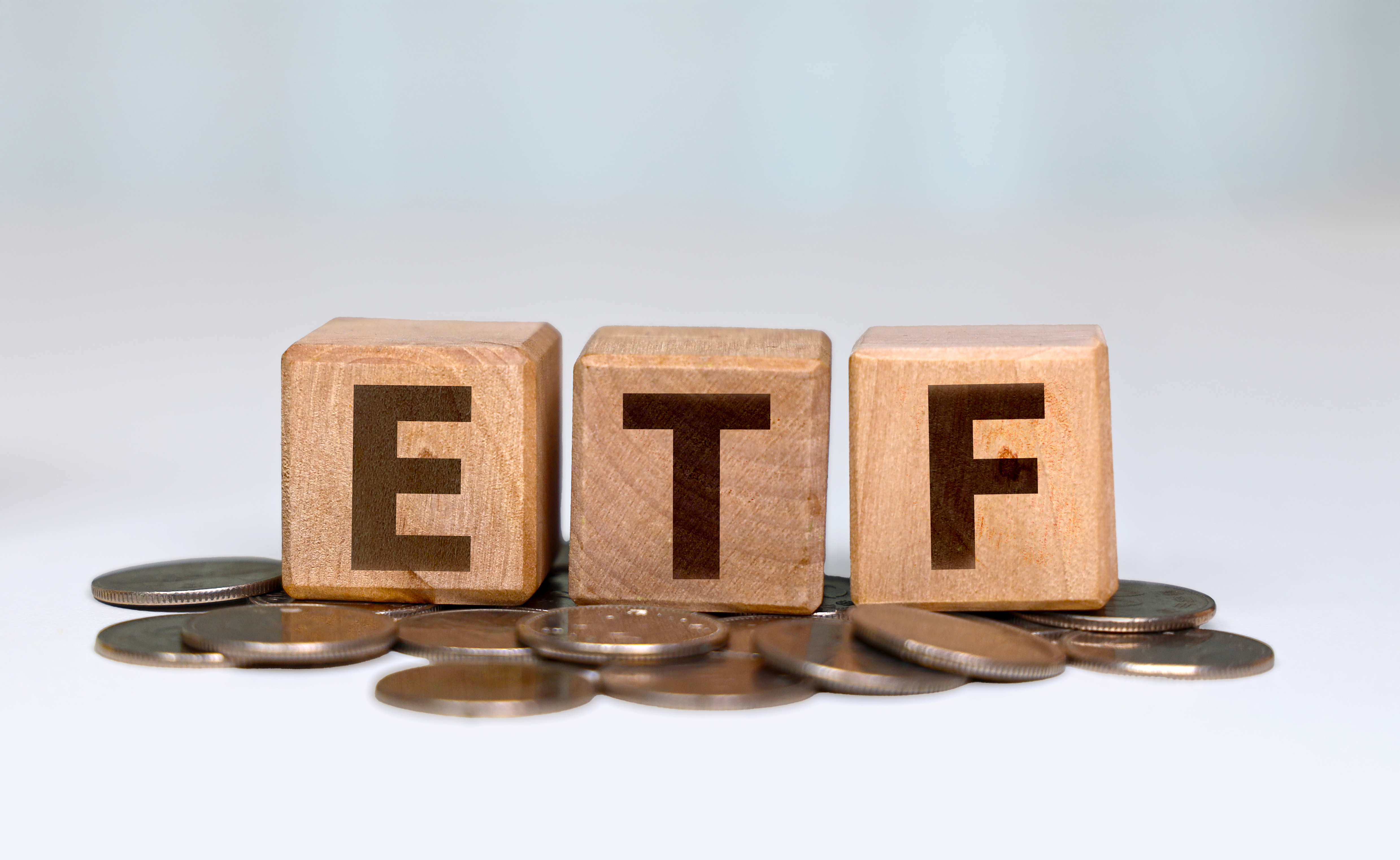 ETF 투자 개념을 상징하는 나무 블록과 동전 이미지, 상장지수펀드의 안정성과 기초 투자 이미지를 표현