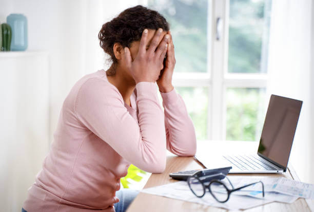 디지털 디톡스를 실패해 노트북앞에서 얼굴을 감싸쥐고 있는 여성