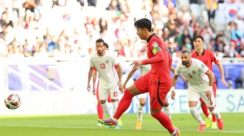 태국전- 붉은 유니폼을 입은 손흥민이 축구그라운드에서 오른발로 공을 차는 모습