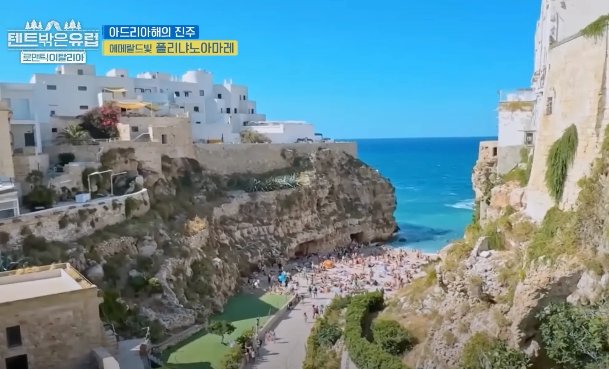 해수욕장에 사람들이 많이 몰려 해수욕을 즐기고 있다. 절벽 사이에 있는 모래사장이다.